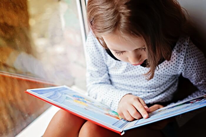 Girl reading by a window