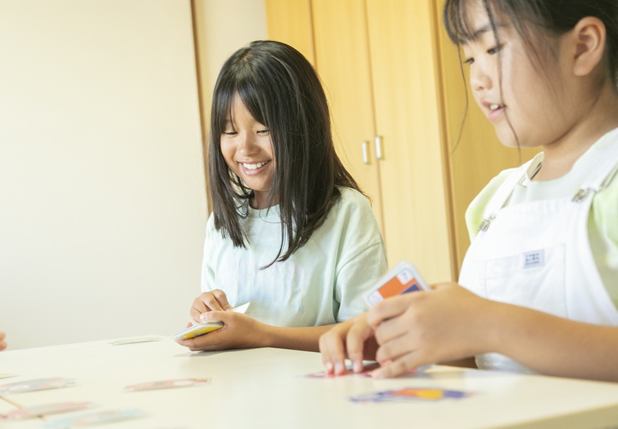 Girls smiling and playing a card game