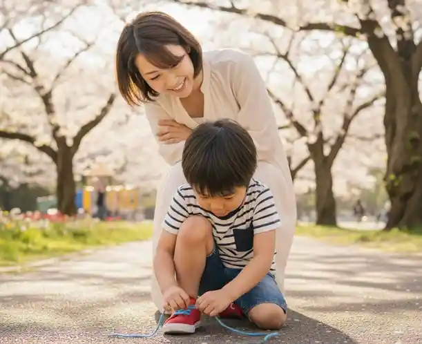 Mum watching her son try to ties his shoe laces