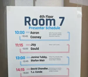 関西英語教育カンファレンスの第4会場(Room 7)発表スケジュール掲示。Aaron Cooney氏のSEO講演が記載されている